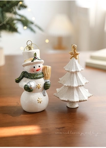 Vue détaillée des ornements bonhomme de neige et sapin avec paillettes sur bois rustique