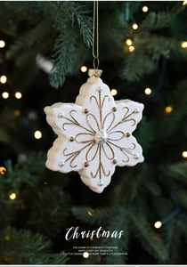 Vue détaillée d'un ornement flocon de neige blanc et doré sur un sapin de Noël festif