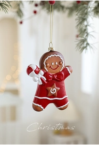 Pendentif bonhomme de pain d'épices avec habit rouge sur une branche de sapin de Noël