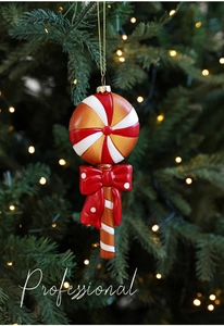 Gros plan d'une décoration de Noël en sucette rouge et or avec un nœud rouge à pois blancs