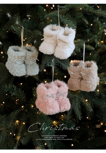 Detail van kleurrijke pluche kerstlaarsjes met strikjes hangend aan een versierde boom