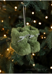 Detail van groene kerstlaars van imitatiebont met zilveren glitterdraad en strikdecoratie