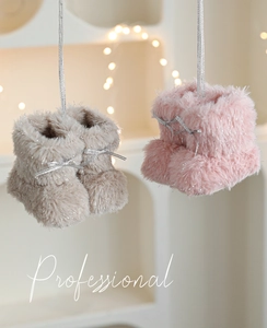 Detail van roze en grijze pluchen kerstlaarzen met zilveren ophangkoorden voor decor