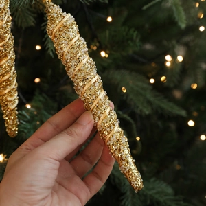 Golden 21cm spiral icicle Christmas ornament with glitter and beads on a festive tree
