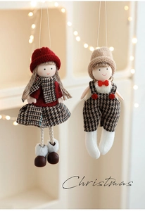 Detail of plush Christmas doll ornaments with plaid skirts and cozy knitted hats