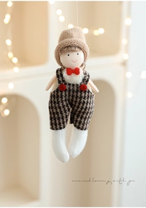 Detail of plush Christmas doll hanging ornament with knit hat and plaid overalls