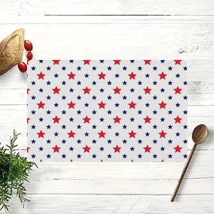 Set de table rectangulaire avec étoiles rouges et bleues sur fond de bois blanc avec pain