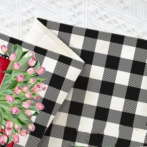 Detailed view of buffalo plaid linen fabric with pink tulip print on crochet background