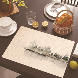 Detail of rectangular place mat with watercolor forest lake print on a wooden dining table
