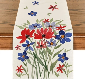 Close-up of linen table runner with watercolor floral patterns on a dark wooden table