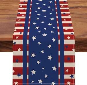 Close-up of linen table runner with red and blue star patterns on dark wood surface