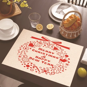 Macro detail of Merry Christmas linen placemat with festive bow and icons on wood table