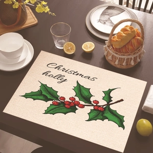 Detailed view of rectangle Christmas place mat with holly leaves on a wood table