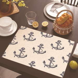 Dettaglio della tovaglietta in lino con motivo ancora blu navy su un tavolo di legno