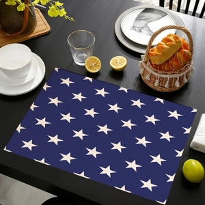 Detail of navy blue star pattern placemat on a wooden table with dining accessories