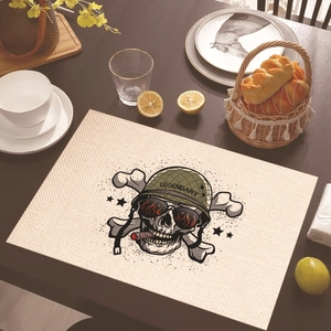 Detail of a skull printed linen placemat with a vintage helmet on a dark wooden table