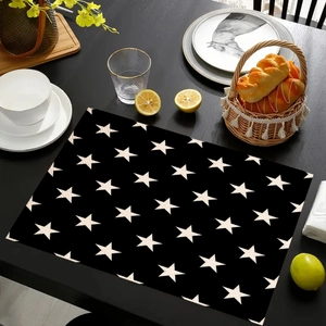 Minimalist black rectangular placemat with white star patterns on a wooden dining table