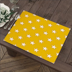 Bright yellow rectangular placemat with white star pattern on a dark wood dining table