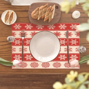 Christmas placemat with red and white snowflake patterns on a rustic wooden table setting
