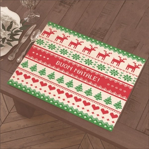 Christmas place mat with reindeer and tree patterns on a wooden dining table