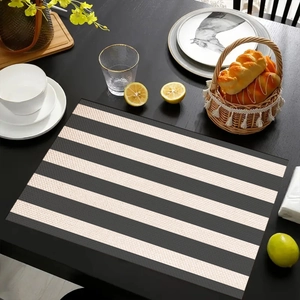 Detail view of linen place mat with black and white horizontal stripes on a dining table