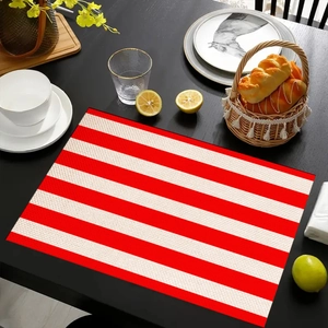 Close-up of red and white striped linen placemat on dark table with dining accessories
