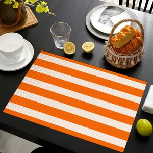 Detailed weave texture of orange and white striped linen placemat on a dark wooden table