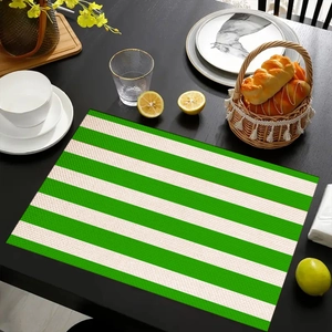 Detail of green and white striped linen placemat on dark wood table for dining decor