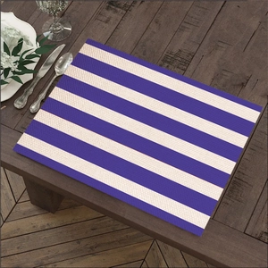 Close-up of linen table mat with blue and white stripes on a wooden table surface