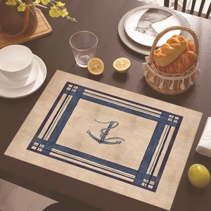 Close-up of nautical placemat with anchor pattern on a rustic wooden dining table