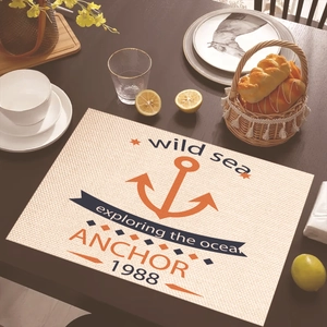 Detail of nautical placemat with orange anchor print on a rustic wooden dining table
