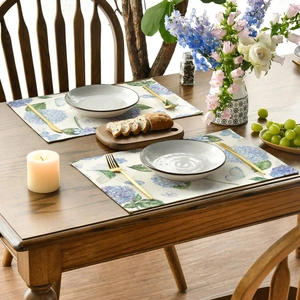 Detail of premium hydrangea and butterfly placemats set on a rustic wooden table
