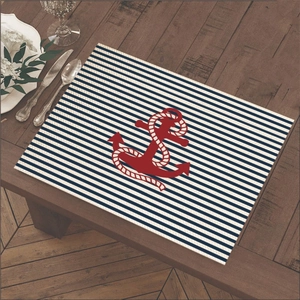 Nautical style table mat with blue stripes and red anchor on a dark wooden table