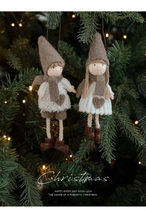Detail von Weihnachts-Plüschpuppen mit Filzhüten, die an einem festlichen Baum hängen