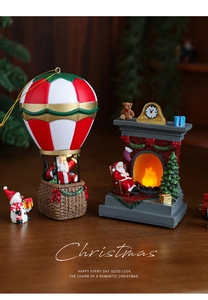 Detail of glowing Christmas fireplace and Santa hot air balloon resin figurines