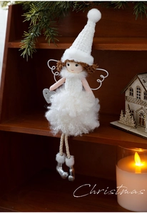 Detail of plush Christmas angel doll with white faux fur dress and silver heart ornament