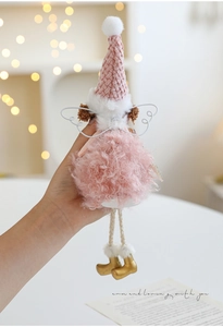 Close-up of pink plush angel ornament with knitted hat and golden boots for Christmas
