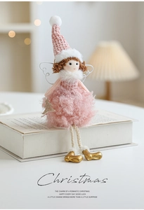 Pink plush angel doll with knit hat and gold boots sitting on a white book decor