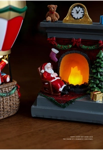 Detailed view of resin Santa by a glowing fireplace with warm LED lights and decor