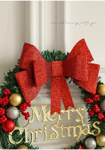 Détail de couronne de Noël avec nœud rouge scintillant, baies et inscription