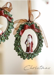Detail of resin Christmas wreath ornament with Santa Claus and a red bow decoration
