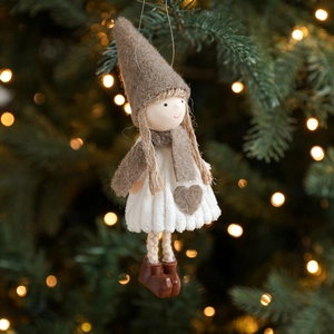 Nordische Weihnachts-Plüschfigur mit grauem Hut und weißem Strickkleid am Tannenbaum