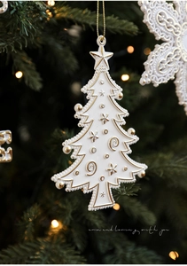 Detail of white resin Christmas tree ornament with gold embossed stars and spirals