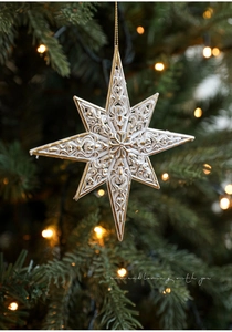 Detail of white and gold star ornament with ornate patterns on a Christmas tree