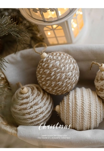 Christmas jute and cotton rope balls in a woven basket with pine branch and wooden beads