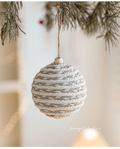 Macro detail of a 8cm cotton and jute woven Christmas ball ornament with wooden bead decoration