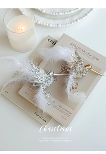Detail of glitter hummingbird Christmas ornaments with soft feathers on vintage books