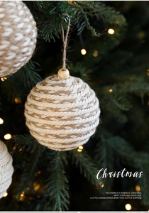 Detail of 8cm woven cotton rope Christmas ball ornament hanging on a pine tree branch