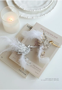 Close-up of sparkling bird ornaments with shimmering rhinestones and soft white feathers