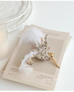 Exquisite golden hummingbird ornament with white feathers and sparkling rhinestones